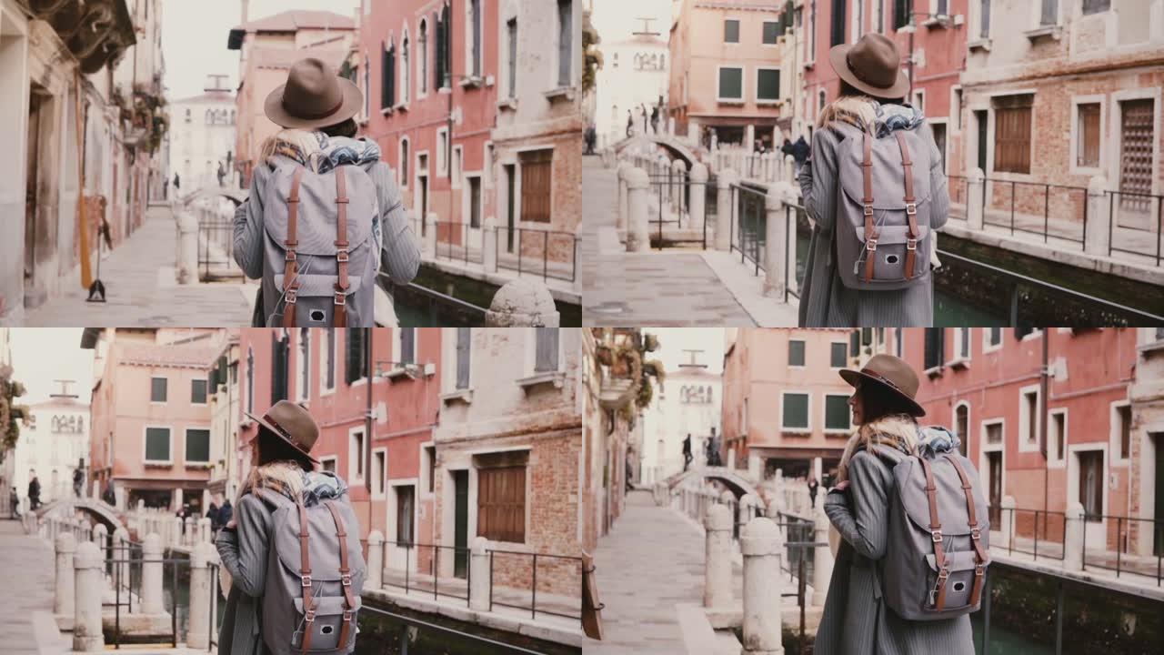 快乐美丽的女游客喜欢沿着意大利威尼斯的水渠街散步，慢动作。