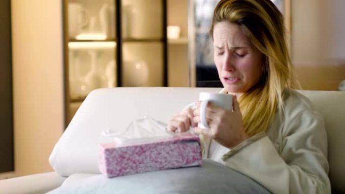 一名妇女坐在她家的沙发上，拼命地哭着抱着枕头，用手帕擦干眼泪。