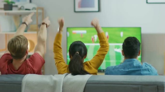 在家里，各种各样的体育迷坐在沙发上观看电视上的重要足球比赛，他们为球队加油，在球队进球后庆祝胜利。朋