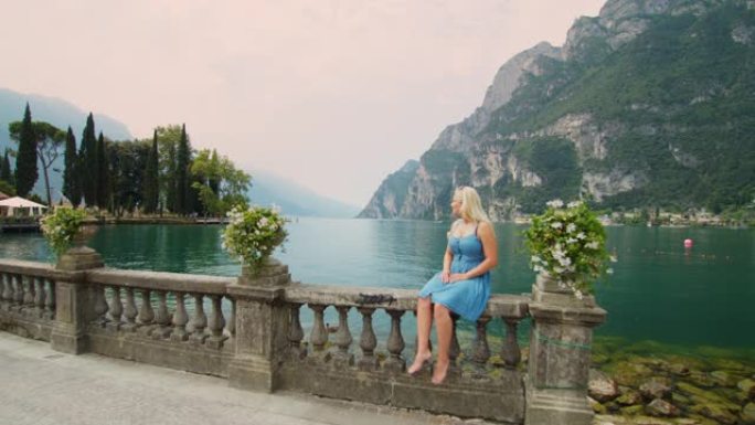 WS无忧无虑的年轻女子坐在意大利加尔达湖田园诗般的宁静湖畔