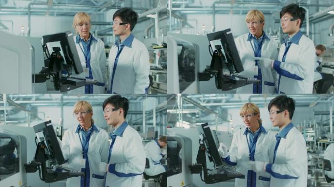 在高科技工厂，亚洲工程师与女主管交谈，使用计算机编程拾取和放置印刷电路板表面安装装配线的电子机械。用