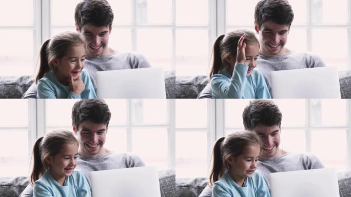 微笑的年轻爸爸教小孩子女儿用笔记本电脑笑