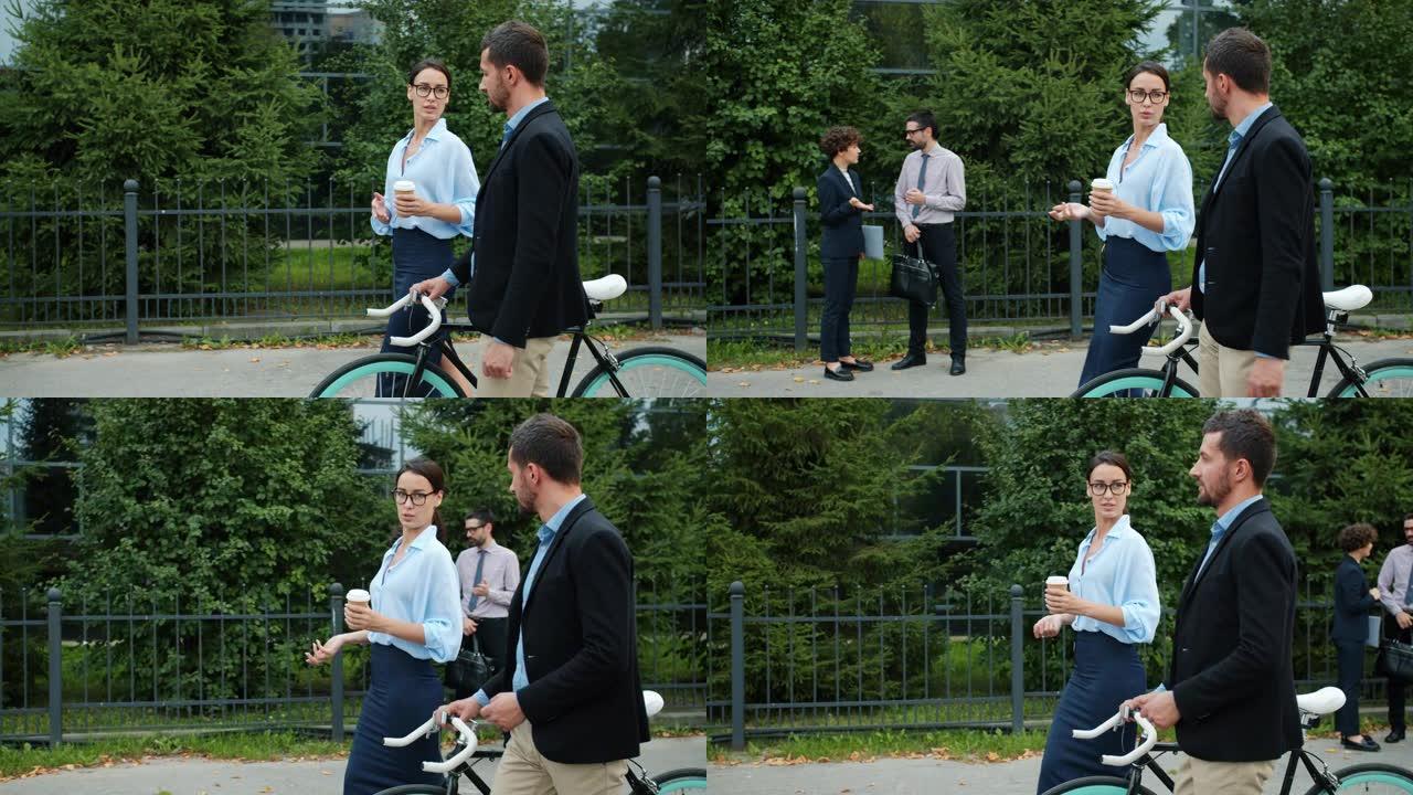 快乐的女孩和男孩同事在城市街道上散步，男人推自行车
