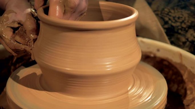 陶器工人在特殊的轮子上制作了一个粘土花瓶。