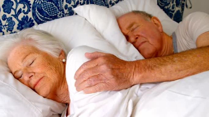 白人高级夫妇睡在舒适的家4k卧室的床上