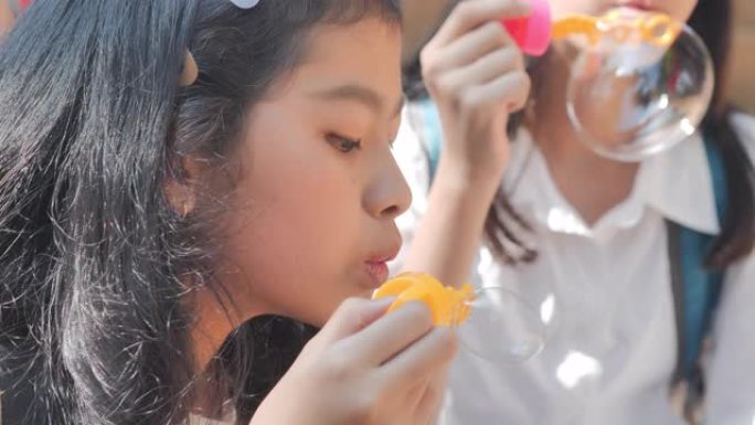 亚洲团体少女放学后在春天公园或夏天吹肥皂泡的乐趣。