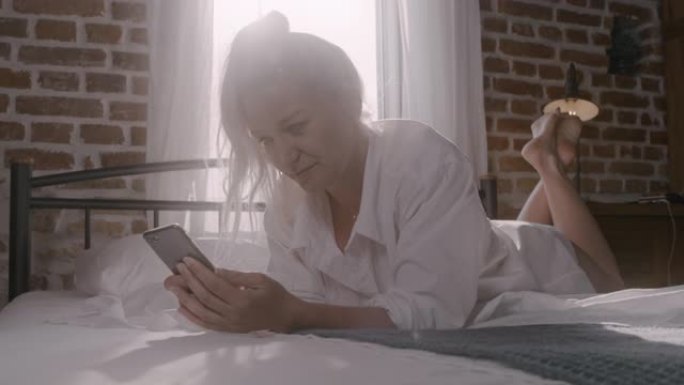 WS女子在床上跳跃时拿着手机