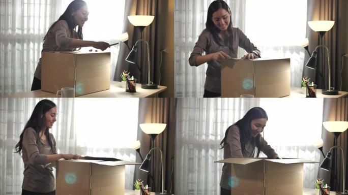 美丽的年轻亚洲女人在家打开纸箱