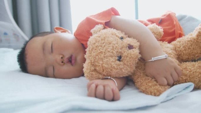 小亚洲男婴与泰迪熊睡觉