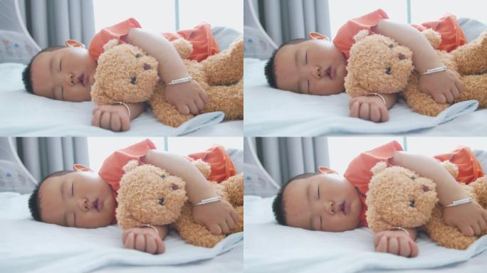 小亚洲男婴与泰迪熊睡觉