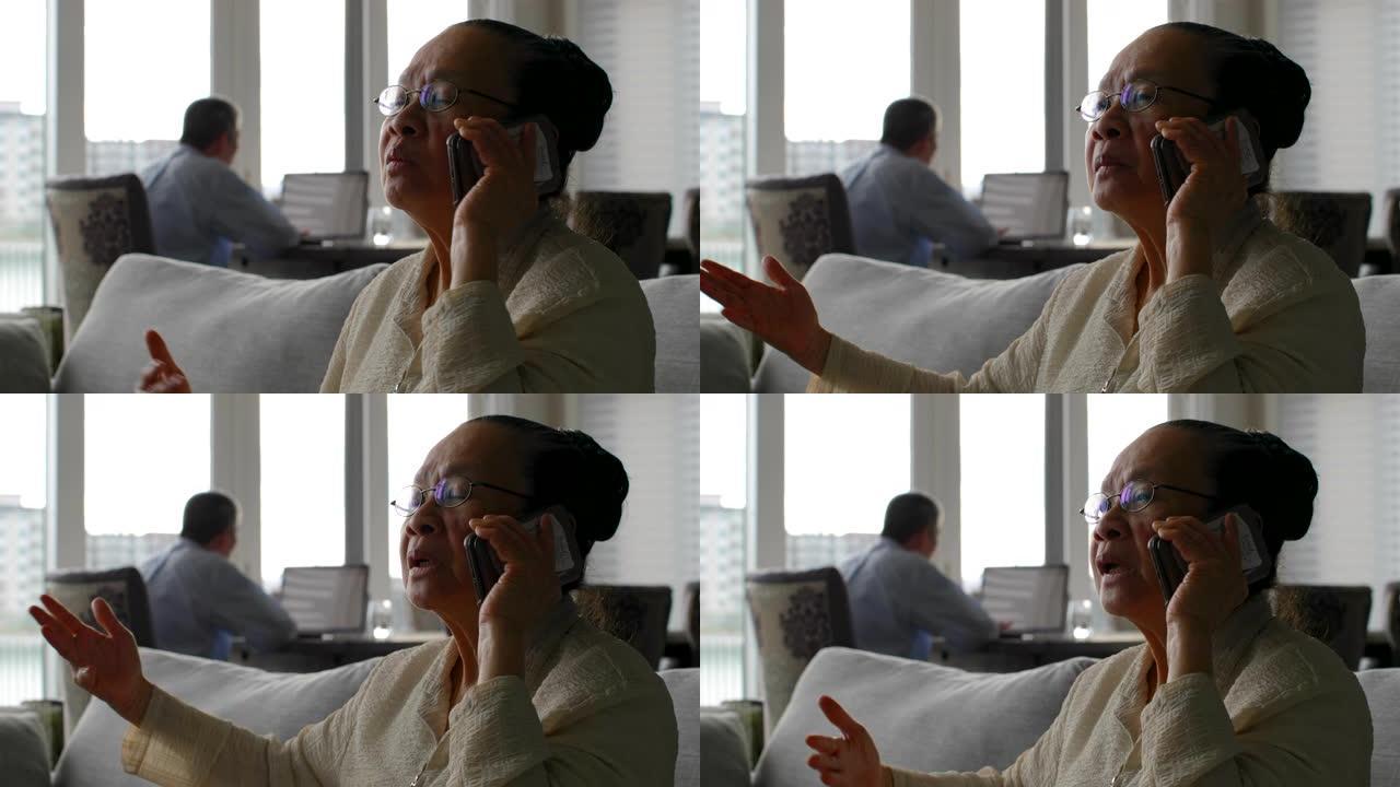 在舒适的家庭中，亚洲老年女性在手机上聊天的前视图4k