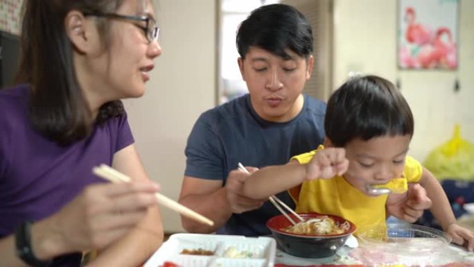 亚洲男孩和他的爸爸和妈妈一起吃玉子烧，日本鸡蛋