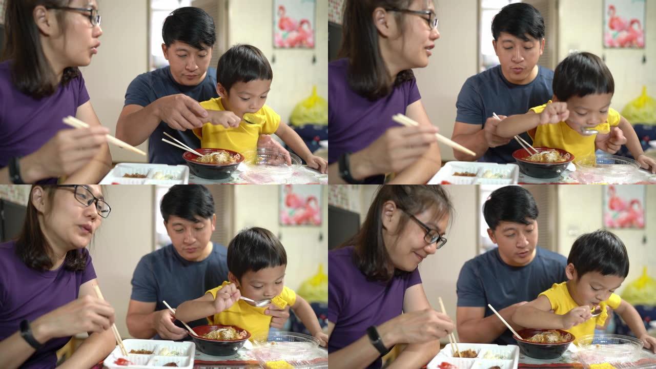 亚洲男孩和他的爸爸和妈妈一起吃玉子烧，日本鸡蛋