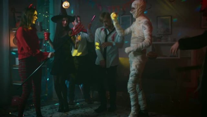 万圣节服装派对: 一群年轻的怪物在装饰有迪斯科球灯的房间里跳舞、喝酒和玩乐。僵尸、嗜血的德古拉、木乃