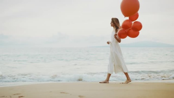 带着红色气球在沙滩上散步