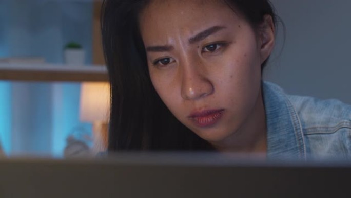 千禧一代年轻的中国女商人深夜工作，在现代家庭的客厅笔记本电脑上解决项目研究问题。