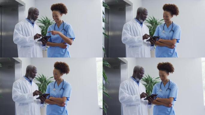 站在医院的多元男女医生讨论平板电脑
