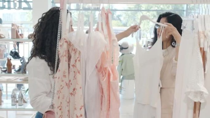 优雅的亚洲女性购物服装与平板电脑女售货员交谈