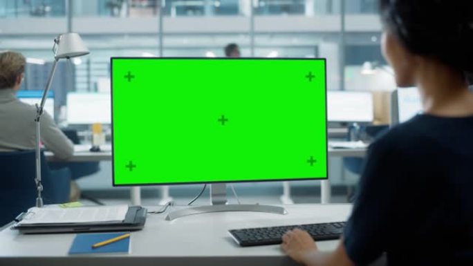 用色度键绿屏模拟显示在台式计算机上工作的女商人的肩膀特写镜头。数字项目经理使用键盘和鼠标键入数据。