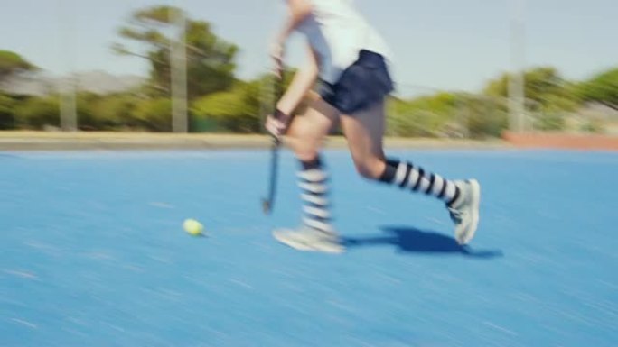 曲棍球运动员的特写镜头在astroturf的比赛中使用棍棒推球并得分得分以获胜。参加团体运动比赛的现