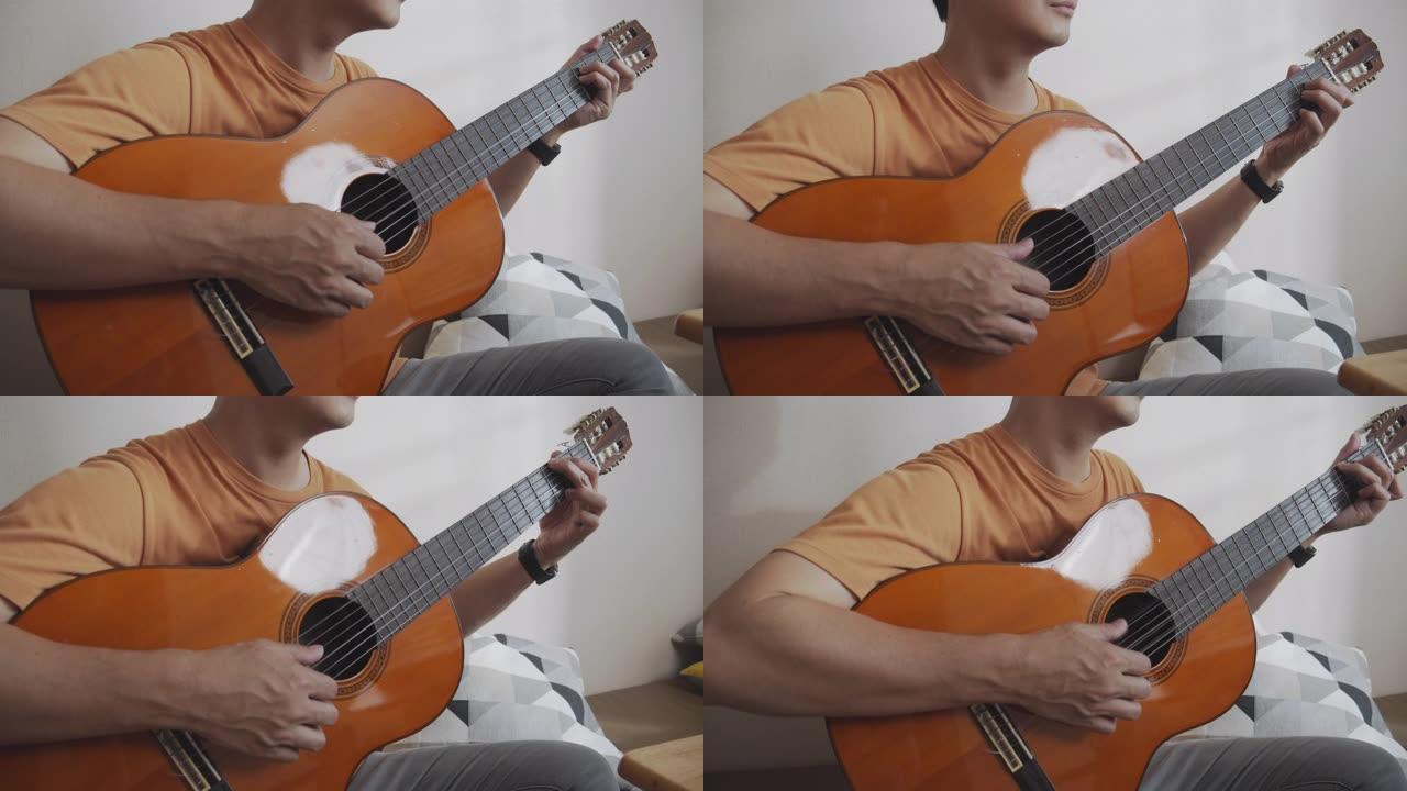 特写镜头亚洲男性通过互联网上的视频通话与他的朋友一起弹吉他电话会议。玩古典吉他的人很开心。音乐家男子