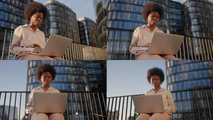一位皮肤黝黑的年轻女商人在她的笔记本电脑上对着商务中心输入一封电子邮件