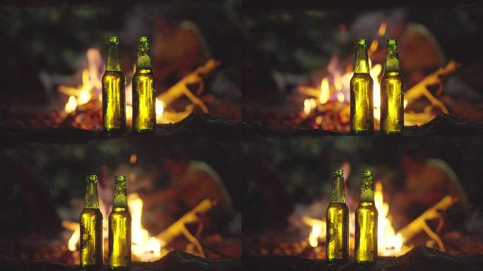 SLOMO两人在篝火前打开了一瓶啤酒