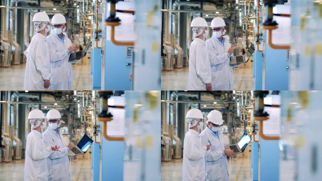 两名穿着实验室外套的专家正在操作工厂设备