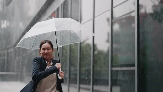 慢动作亚洲女商人在雨中带伞跑步
