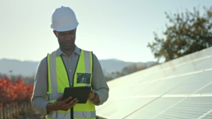 太阳能电池板，可再生能源农场和带平板电脑的工程师进行维护检查。黑人在太阳能发电厂上行走，采用数字技术