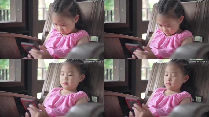可爱的小女孩用智能手机在长凳上放松