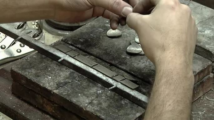 工匠在阿根廷布宜诺斯艾利斯的工作室焊接Yerba Mate杯的金属环。特写。