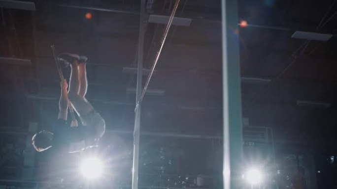 撑杆跳跳高冠军: 职业男运动员用杆子跑成功跳杆。训练中冠军的确定。戏剧性的色彩，运动成就的慢动作