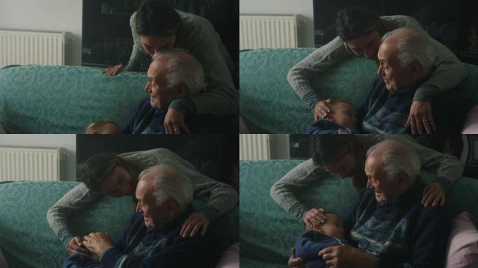 电影拍摄的《快乐的女儿》拥抱着一个父亲，坐在家里的沙发上睡着了孙子婴儿。生活观念，祖父母，世代，童年