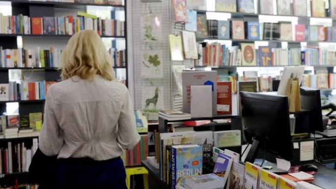 妇女在大流行期间在商店购买书籍