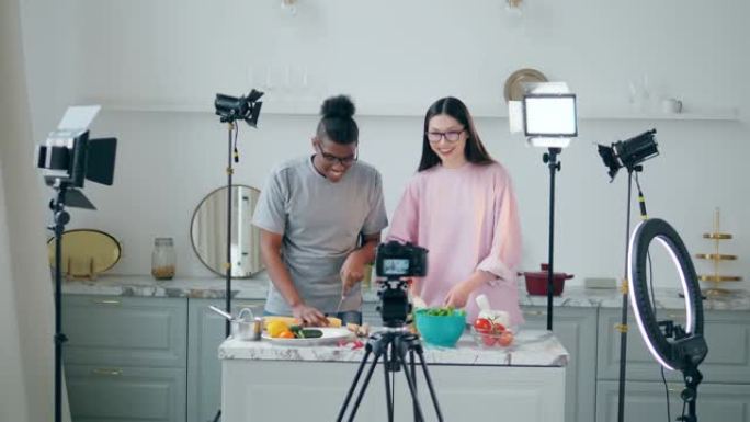 在线vlog，博客录制视频，在线流媒体概念。几个年轻人在工作室拍摄时正在做饭