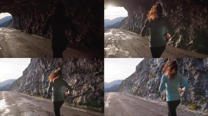 以健康为导向的妇女在山上高高的岩石隧道中奔跑