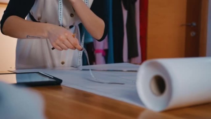 SLO MO Young女裁缝在绘制未来面料产品轮廓时使用数字平板电脑