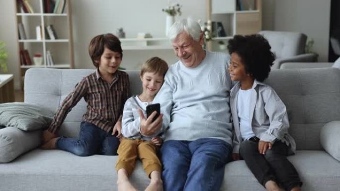 曾祖父与孙子们一起使用智能手机玩得开心