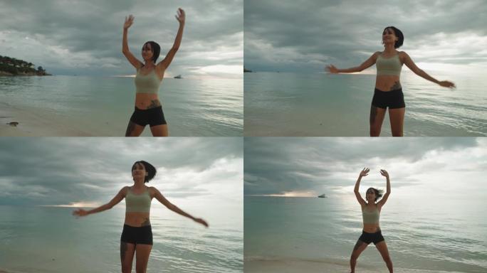 女人在海滩上锻炼纹身女人自然风光海洋海水