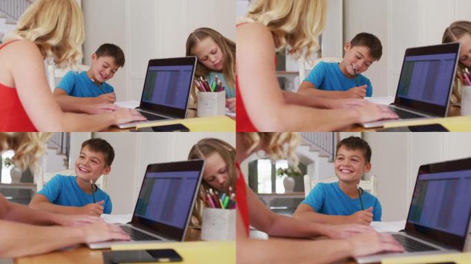 白人母亲在家里使用笔记本电脑时帮儿子做作业