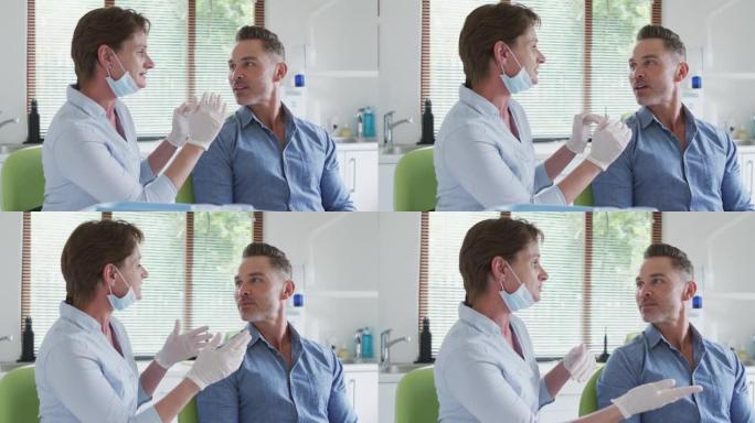 在现代牙科诊所，戴着口罩的高加索女牙科护士与男性患者交谈
