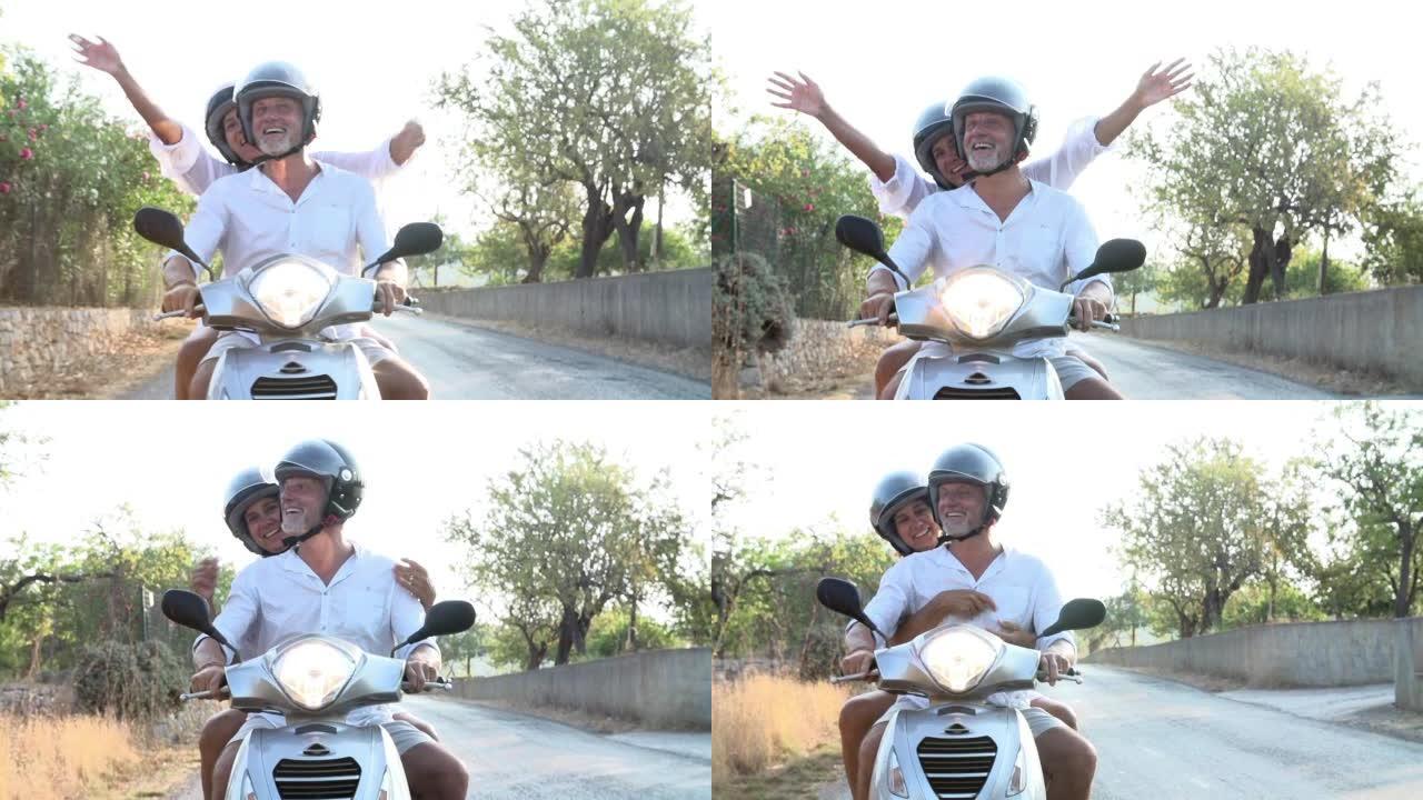 成熟的夫妇沿着乡间小路骑摩托车