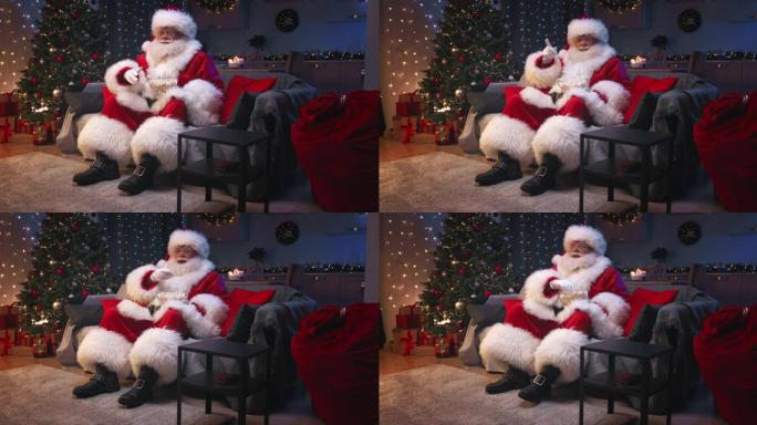 圣诞老人坐在装饰精美的客厅里过圣诞节，坐在灰色的沙发上看电视，吃着爆米花。圣诞老人对电影的情节做出了
