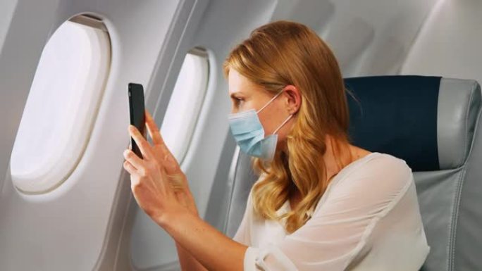 飞机上的智能手机坐在飞机上拍摄窗外乘坐飞
