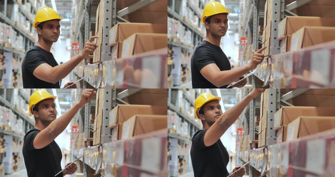印度种族仓库工人戴着防护工作头盔在仓库工作，同时检查工业工厂仓库货架托盘上的产品。仓库概念。