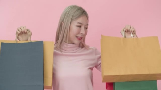 年轻购物狂亚洲妇女拿着纸袋购物的肖像。