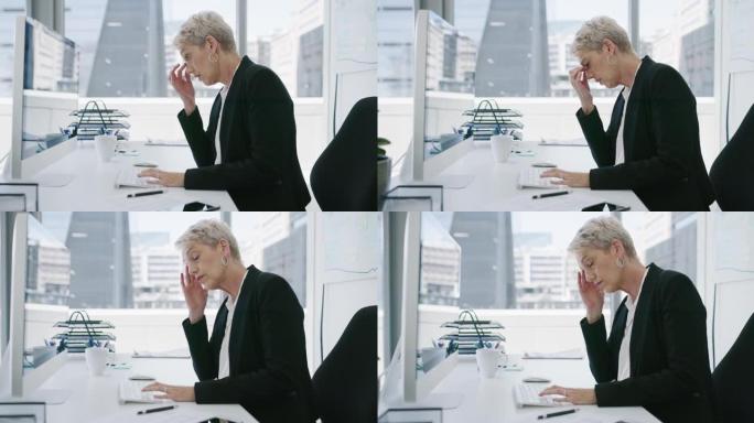 一个成熟的女商人在办公室的电脑上工作时看起来压力很大的4k视频片段
