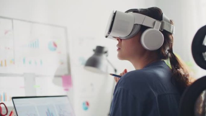 Metaverse: 戴着VR眼镜的亚洲妇女在办公室工作