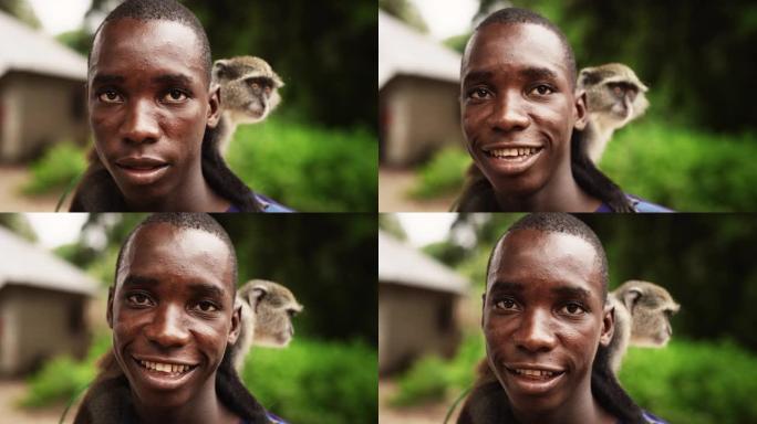 特写一幅真实的非洲男子的肖像，他背着一只小猴子看着相机，背景是绿色的微笑。带着幸福笑容的黑人友好男性